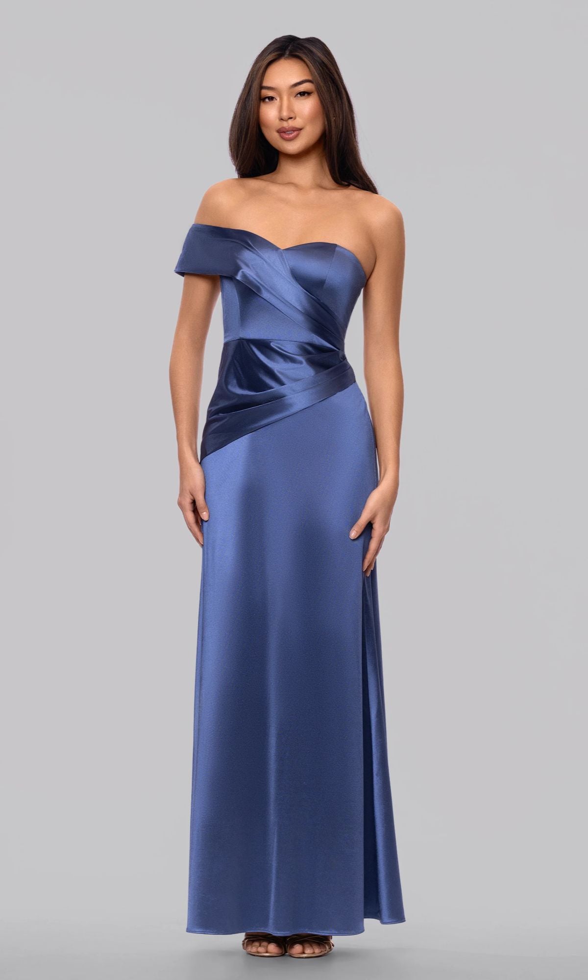 A woman poses against a plain background in the Blondie Nites 6164BN Long Prom Dress, featuring a slate blue, off-the-shoulder design with an asymmetrical satin bodice and a graceful floor-length skirt.